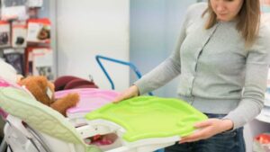 woman choosing high chair in a children's store